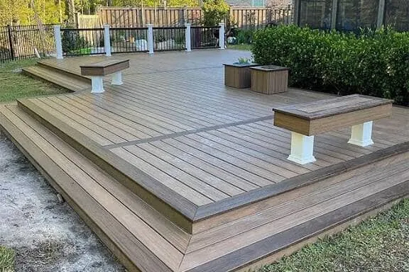 Paved outdoor area with built garden edging and steps beside a freshly cut lawn