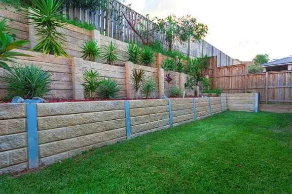 Front lawn running up to a timber fence with a low trimmed border of shrubs